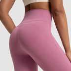Pink leggings worn by a person on a light gray background