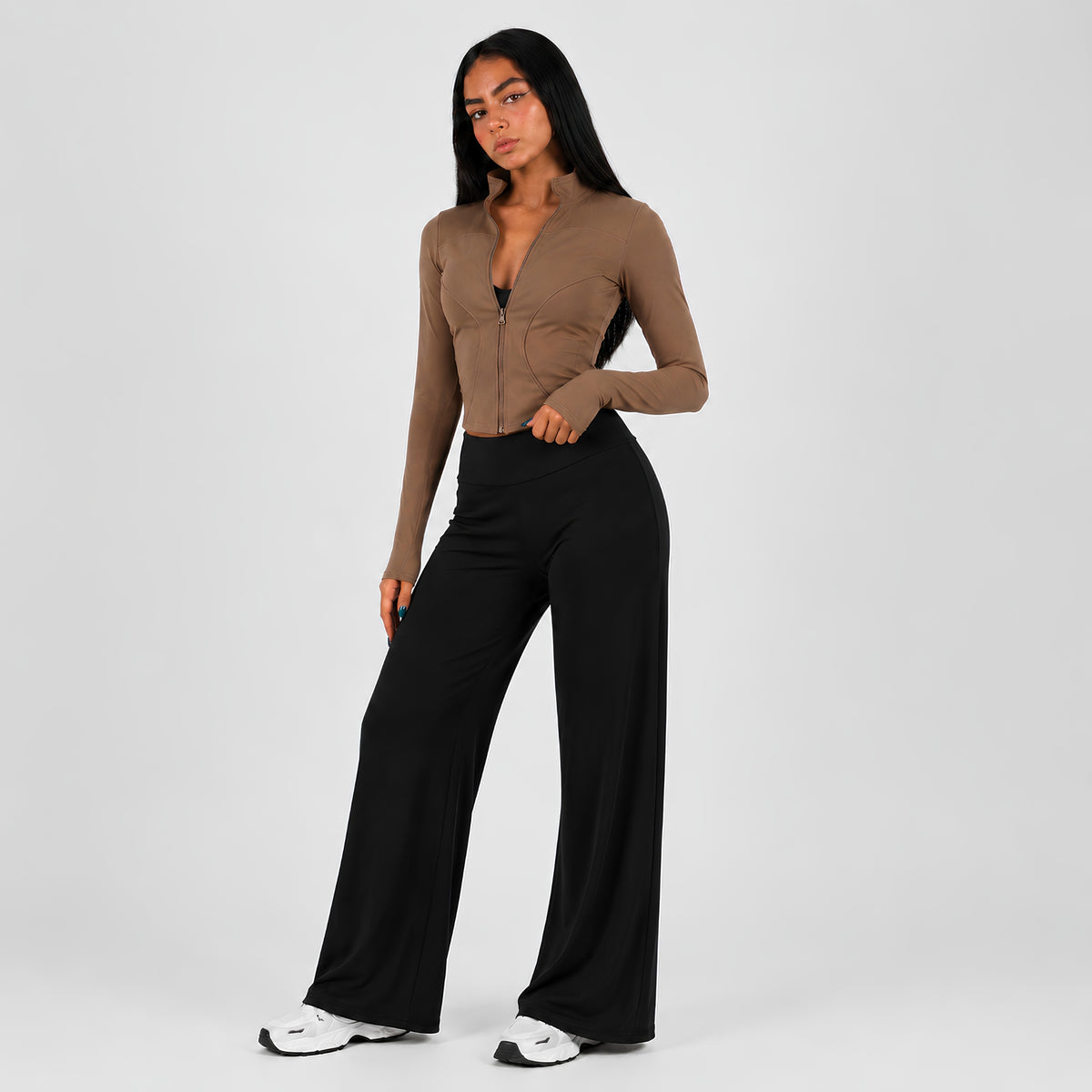 A woman modeling a Taupe long-sleeve zip-front top and wide-leg pants against a light studio background.
